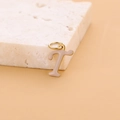 Pink enamel letter T pendant in gold finish stainless steel on a stone prop - Enamel Letter-T