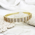 Close-up of gold geometric devil eye bangle with pave-set zircon on white lace background - Style 5 8.3mm Wide