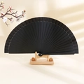 Classic black silk folding fan with bamboo frame on wood stand with cherry blossoms - Black
