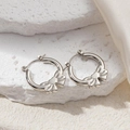 Macro shot of silver bow earrings with polished metal texture on white stone background - Bowknot Style Earrings (0216)