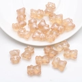 Macro shot of 12x14mm translucent resin bear beads for DIY jewelry and crafts in soft flesh pink - Frosted Amber Gold