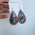 Close-up of wooden teardrop earrings with colorful leaf patterns on a display card - Colorful Leaves