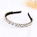 Luxe rhinestone headband with emerald-cut crystals and gold claw setting on black velvet - White
