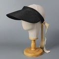 Detail of a black straw visor hat featuring a wide brim and elegant beige silk bow ribbon - M (56-58cm) / Black + Beige Ribbon