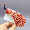 Elegant gold peacock brooch featuring vibrant red crystals and colorful rhinestone accents - DW1056 Peacock / 132*36mm / Red