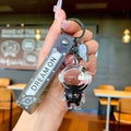 Macro detail of astronaut keychain with flowing purple liquid, sequins and Dream On strap - Black Gold Astronaut Skateboard
