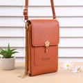 Detail view of orange PU leather crossbody phone bag on a stylish display surface - Tan