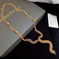 Detail van gouden meerlaagse ketting met geknoopte kwastjes en kralen op luxe verpakking - Goud