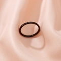 Polished black minimalist band ring shown on elegant pink silk fabric background - Black