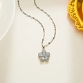 Elegante zilveren bloemenketting met lichtblauwe zirkonia op een beige achtergrond - Witte Zirkonia Bloem (574)