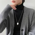 Silberner ovaler Anhänger an feiner Kette auf schwarzem Strickpullover für Damen - Stil 15 Halskette - Silber