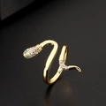 Macro shot of gold snake ring with sparkling white cubic zirconia and green gem eyes - Gold Green Eye Snake Wrap Ring