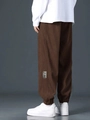 Close-up of brown corduroy cargo pants with stitched 'Goodideas' textile label - Coffee