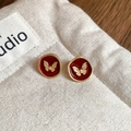 Close-up of vintage red seal earrings with golden butterfly motif on white fabric - Drip Oil Irregular Round Butterfly Stud Earrings