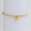 Nahaufnahme eines goldenen Perlenarmbands mit rundem Buchstaben-A-Anhänger auf weißem Ständer - Buchstabe A (DB240603-A)