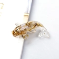 Resin koi fish figurine with shimmering gold foil flakes on a minimalist white surface - Opal