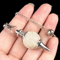 Natural white turquoise stone pendulum pendant with silver chain held in hand - White Turquoise (Synthetic)