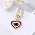 Colorful enamel heart keychain in gold finish with wave edges on a clean white background - Red Dark Blue Heart Eye