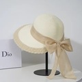 Detail of elegant two-tone woven straw hat with large khaki bow on a display stand - M (56-58cm) / Off White