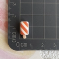 Gros plan d'une glace miniature en résine de 1,9cm avec échelle de mesure précise - Brochette de bâtonnets de crabe