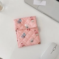 Detailed shot of pink quilted sanitary bag with animal prints on minimalist desk - Pink Doll Pattern