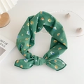 Foulard vert à imprimé fleuri noué en nœud sur un bureau blanc au style minimaliste - Vert Fleurs Jaunes