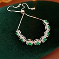 Dettaglio del bracciale vintage regolabile con zirconi verdi su velluto verde scuro - Verde