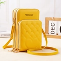 Detailed view of yellow PU leather crossbody bag with three zipper sections and quilted heart - Yellow