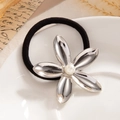 Black ponytail holder with a silver flower charm and central pearl on a white tray - Silver - Pearl Flower