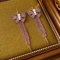 Close-up of pink zircon butterfly tassel earrings with metal crystals on vintage wood - Earring Hooks / Purple