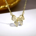 Detailed close-up of a gold bow pendant necklace with micro-paved white zircon crystals - XL1290 Necklace / Gold