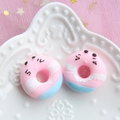 Detailed macro view of pink and blue resin donut charms with cute faces for DIY crafts - Foundation