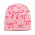 Close-up of pink knitted beanie with jacquard bow patterns and soft wool texture - M / Pink