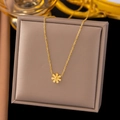 Vista dettagliata di una collana con pendente a margherita dorata su espositore grigio - AH667-Margherita / Oro