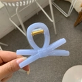Close-up of light blue bow hair clip with translucent acrylic finish and gold metal spring - Sky Blue