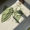 Detailed view of sage green textured bikini set with sarong on a beach-themed background - S / Olive Green