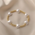 Minimalist beaded bracelet featuring gold metal balls and white heart-shaped faux pearls - Imitation Pearl and Copper Beads / Gold/White