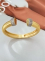Detail van gouden open armband met geribbelde textuur en glinsterende diamanten uiteinden - Bangle / Goud