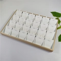 Detail view of a 24-slot jewelry display tray with gold trim and white velvet lining - Gold + White Brushed Leather