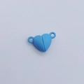 Detalle macro de cierres magnéticos en forma de corazón azul con anillos conectores - Corazón / Azul claro