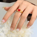 Vintage gold-plated ring with oval red crystal stone on index finger with floral backdrop - Ring / Gold & Red Crystal / US 6