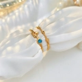 Detailed macro view of two minimalist gold geometric rings with blue gemstone on white silk - Two-Piece Set / Gold/Blue