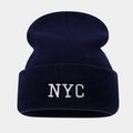 Gros plan sur la broderie blanche NYC d'un bonnet en maille bleu marine texturé - Taille unique / Bleu marine