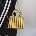 Golden acrylic evening bag with wavy handle and chain strap in a textured rib design - Gold Striped