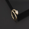Dettaglio dell'anello a serpente dorato con zircone a goccia su espositore geometrico - Anello in Oro Incrociato Con Pietra Principale a Goccia d'Acqua