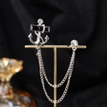 Silver anchor brooch with black rectangular gemstone and double fringe chains on stand - Silver