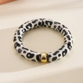 Detailed macro view of retro leopard print acrylic tube beaded bracelet with gold accent bead - Bracelet - Black
