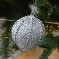 Silver sequin Christmas ball ornament with vertical ridges hanging on a green pine tree - Threaded Silver Foam Ball 8CM