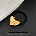 Elastico per capelli nero con ciondolo a cuore dorato, diametro 7,5cm, su sfondo di pelle - Cerchietto Per Capelli In Metallo Freddo - Concavo E Cuore Concavo