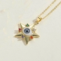 Gold evil eye star pendant necklace featuring multicolored crystals on ivory fabric - Five-Pointed Star Design